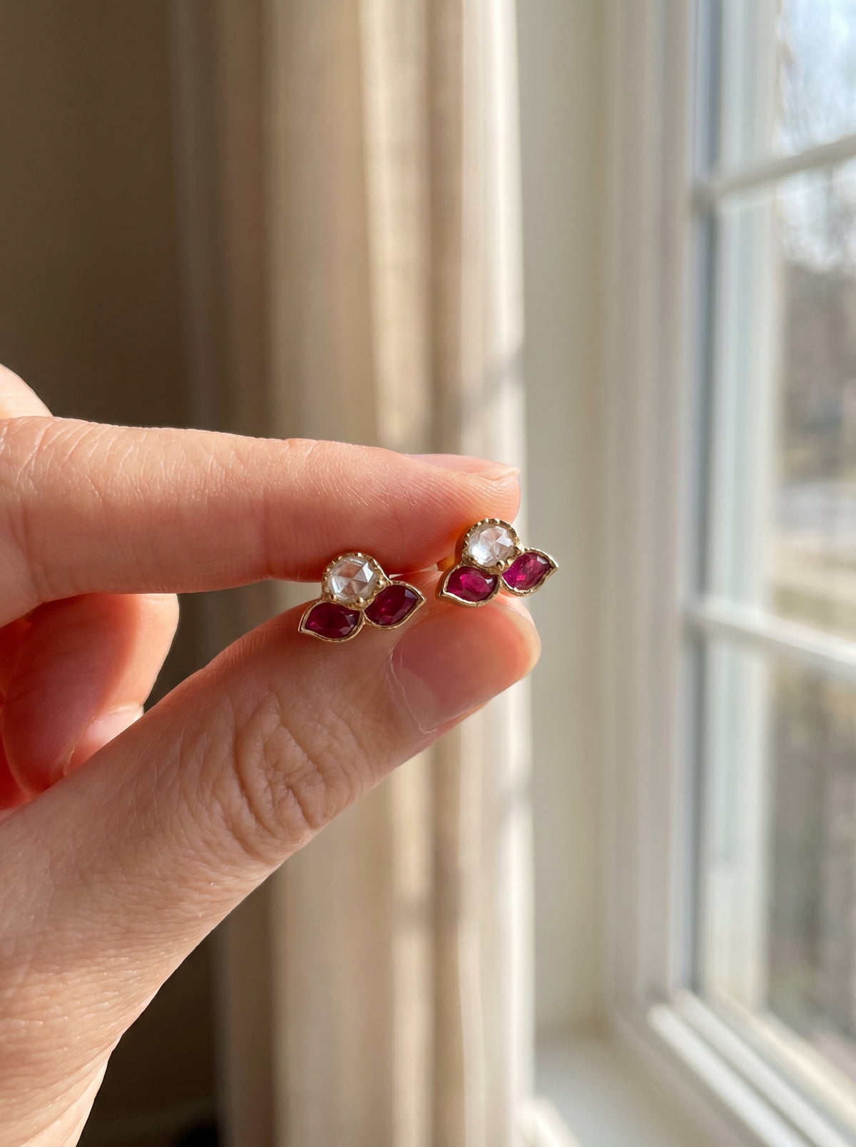 ZEVARAZ Aabha Tulsi Studs held between two fingers for scale