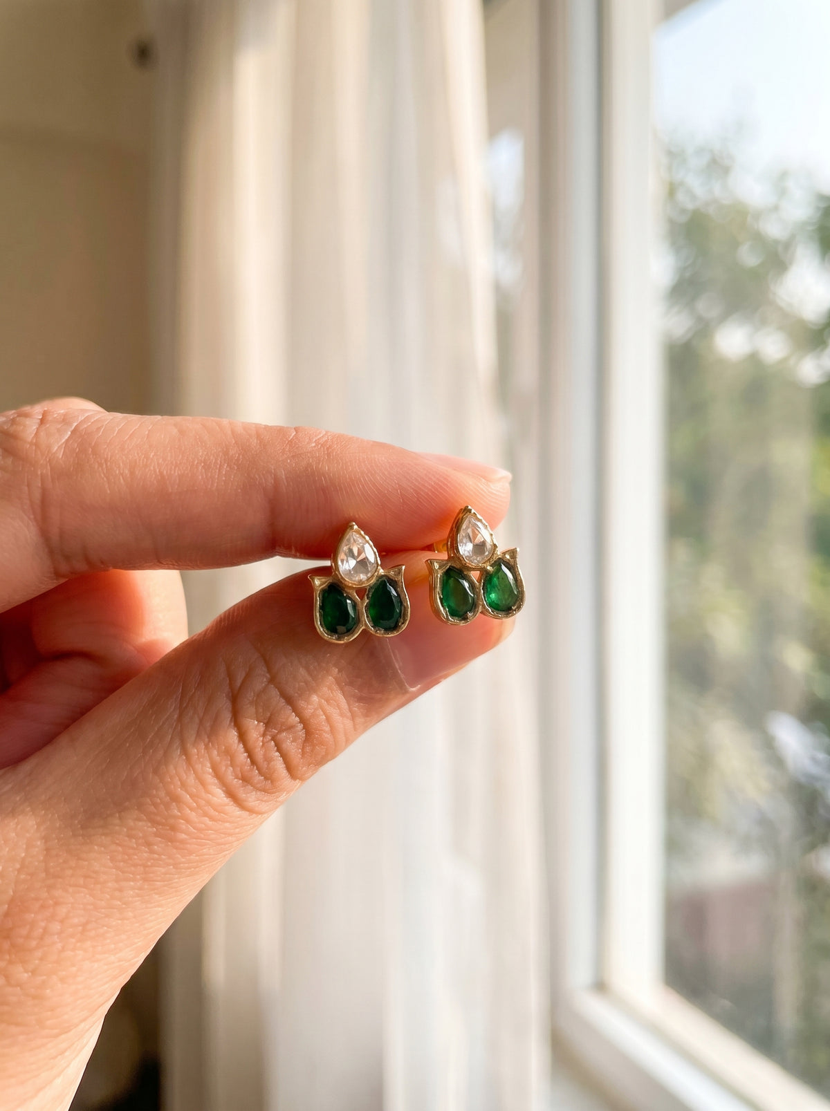 ZEVARAZ Aabha Aasha Studs held between two fingers for scale