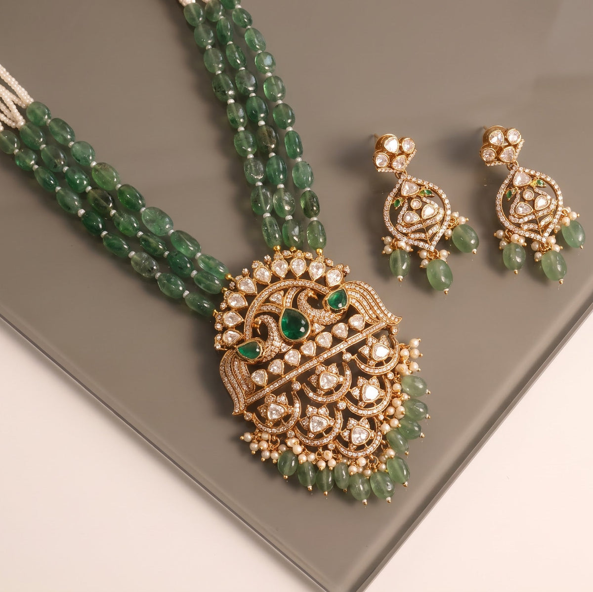 ZEVARAZ Aabha Padak Necklace Set on a smoked glass surface, angled view